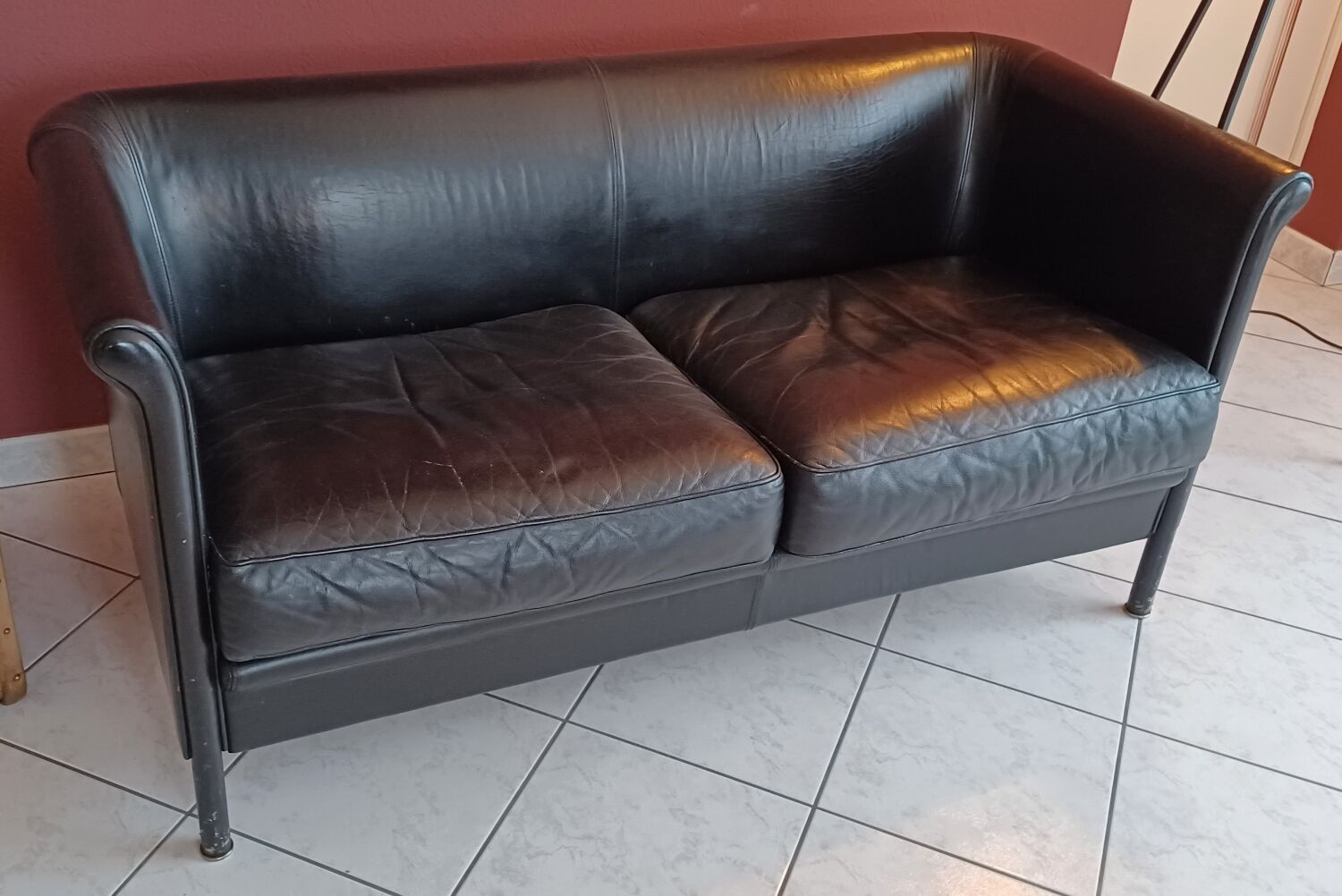 Black leather two-seater sofa