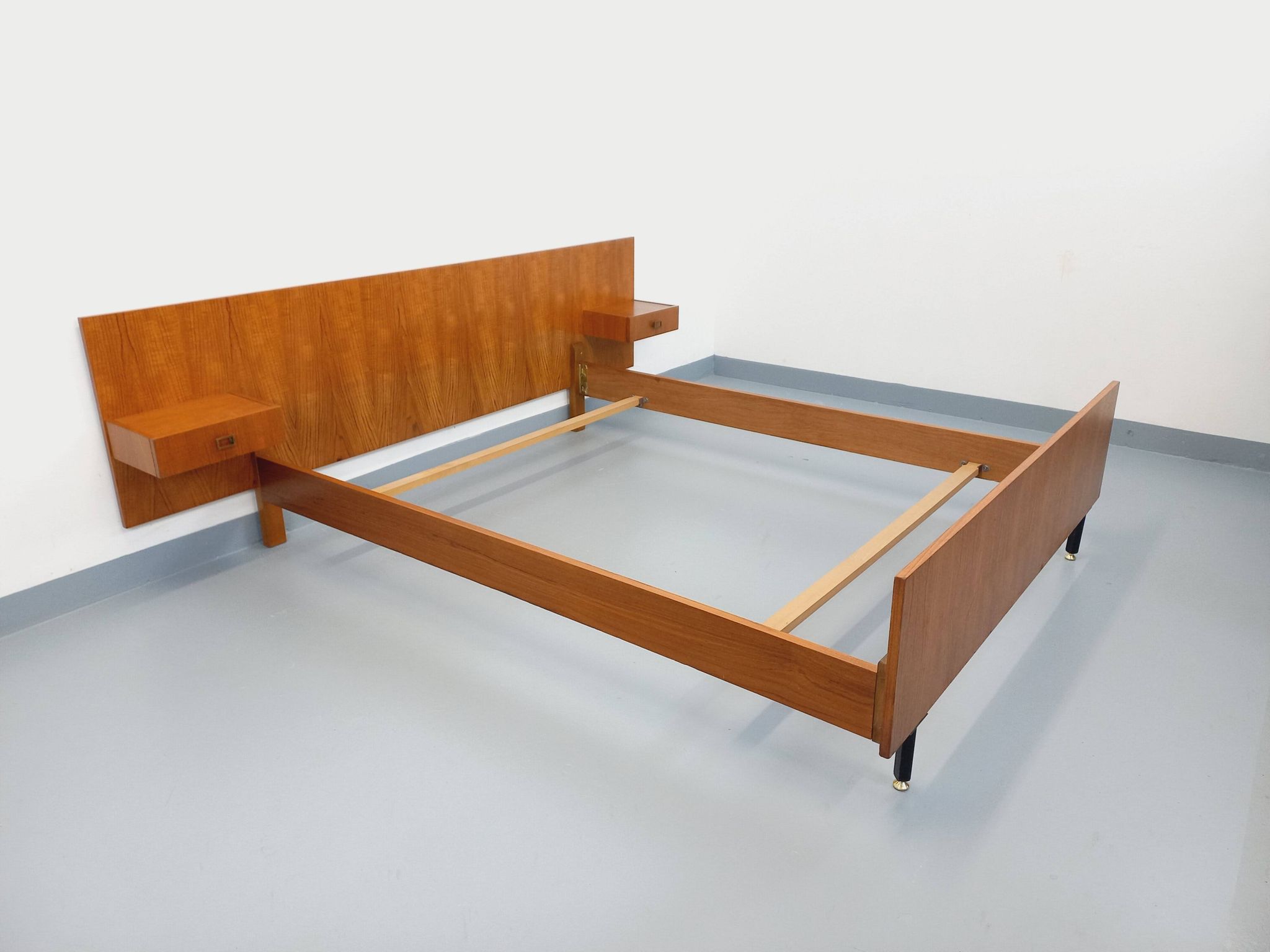 Double bed vintage modernist in teak and black metal from the 1960s with bedside tables.