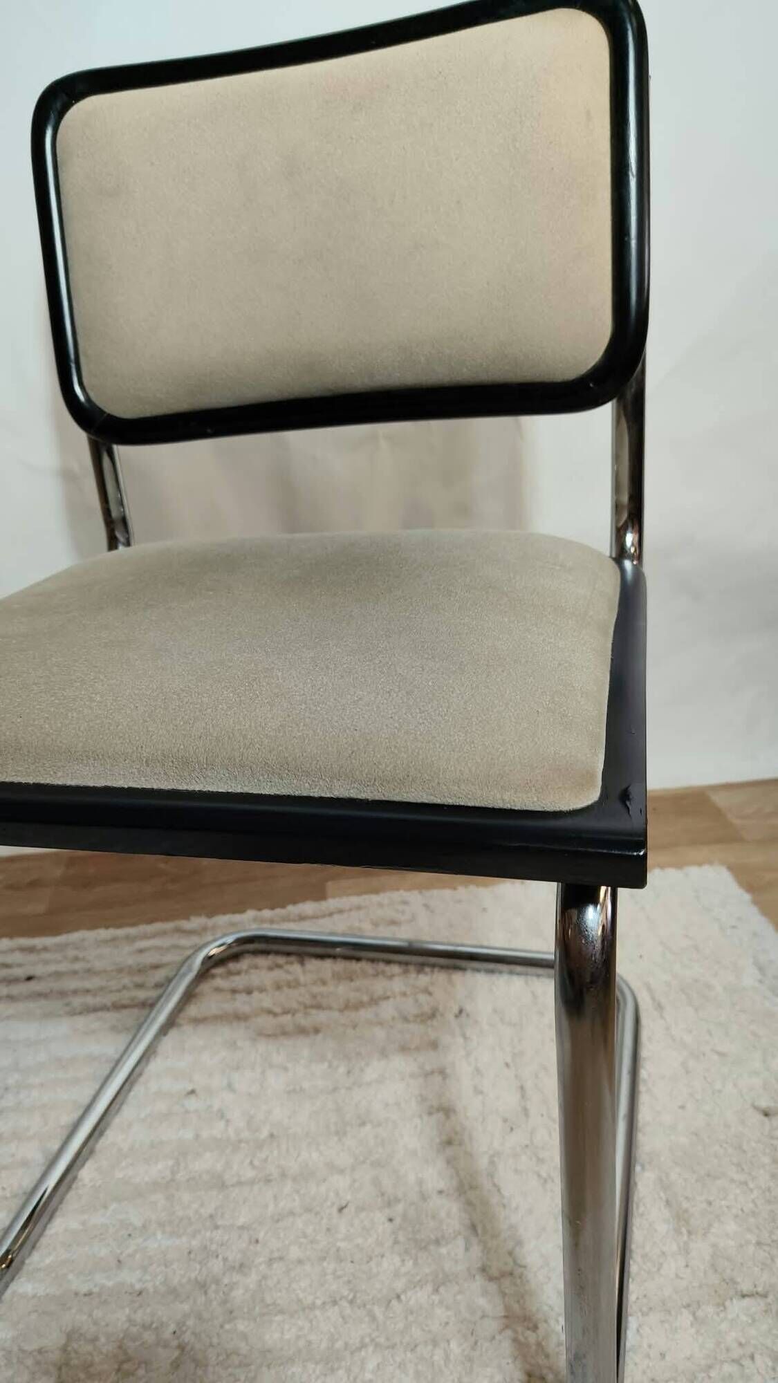 Cesca B32 chair by Marcel Breuer, upholstered in beige fabric.