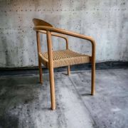 Solid wood chair with weaved seat and armrests
