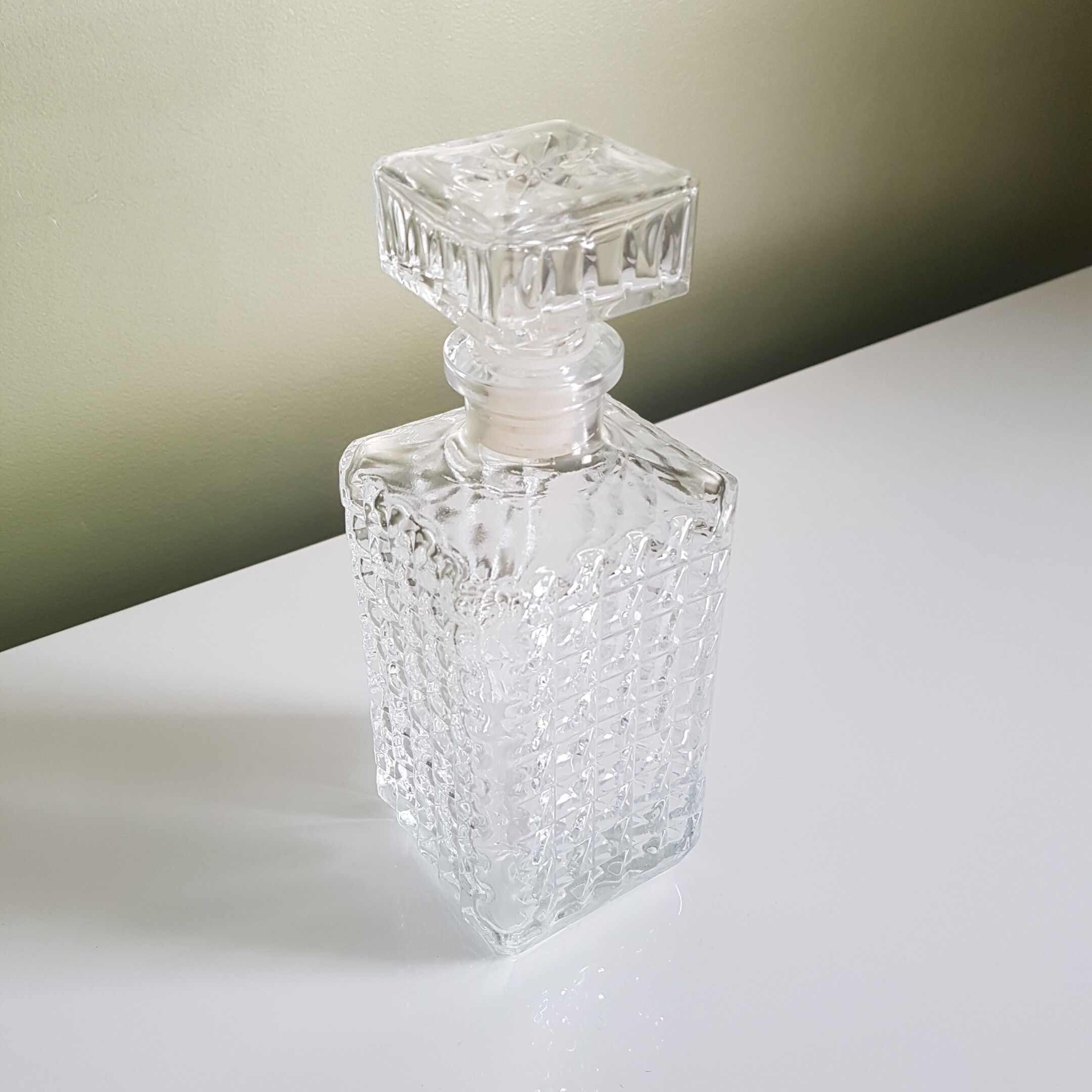 A square glass whiskey decanter