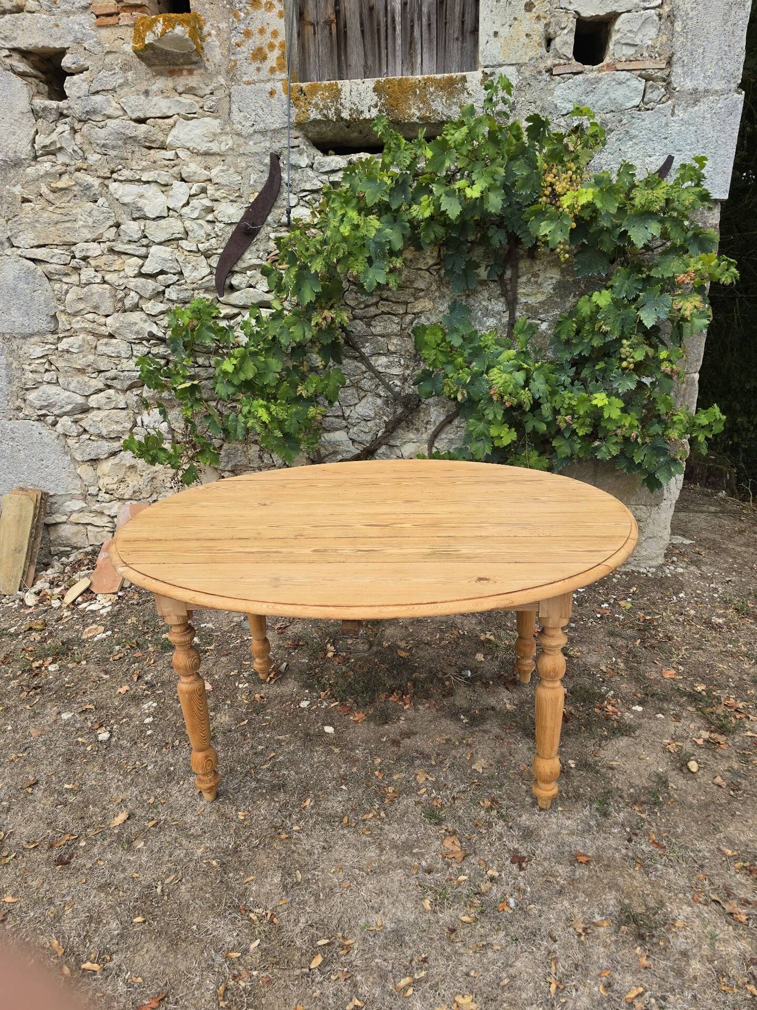 Folding drop-leaf table made of raw solid wood.