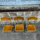 Three folding opera chairs in old gold velvet and brass structure