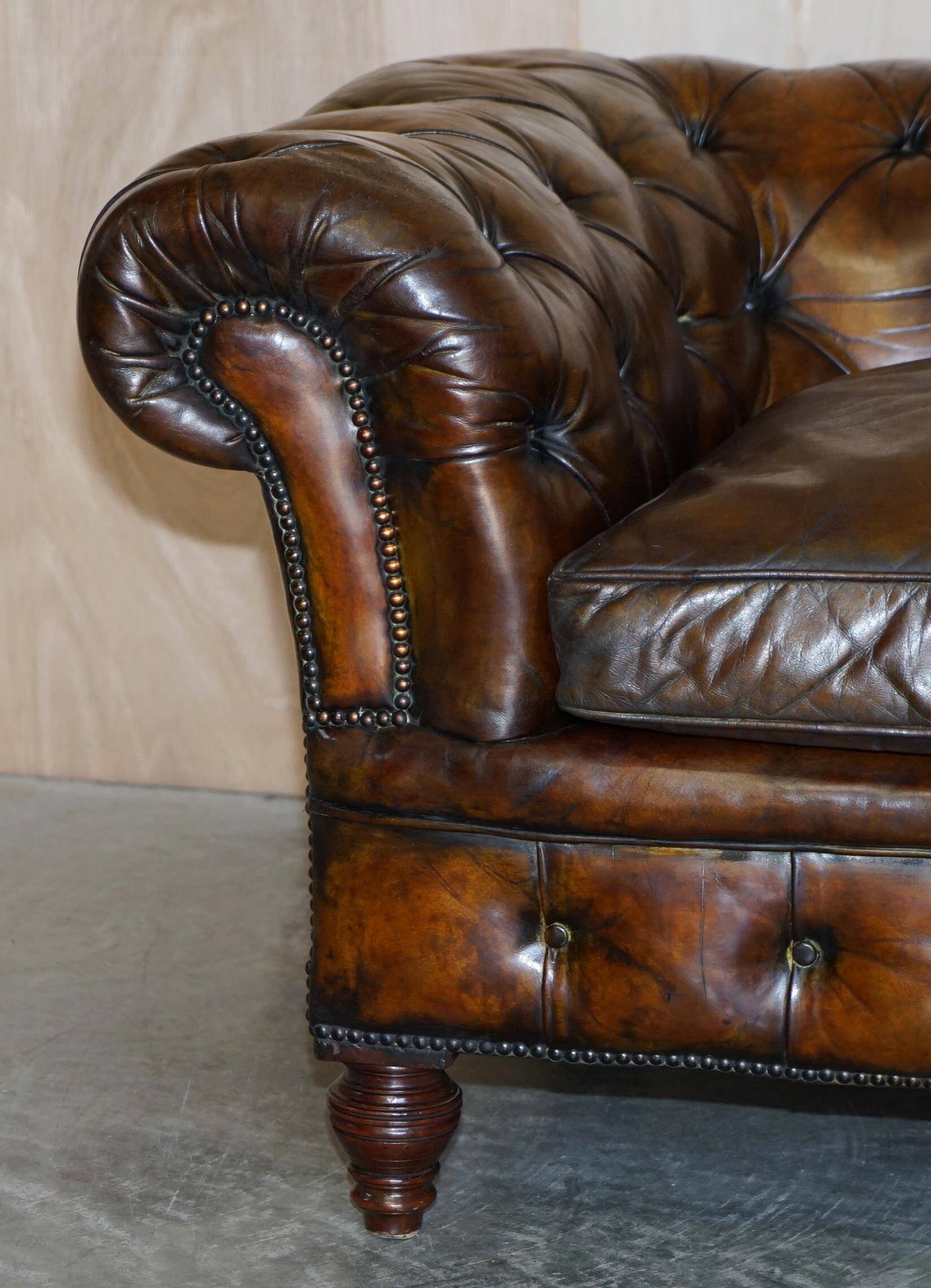 Victorian Chesterfield leather upholstered canapé with feather cushions.