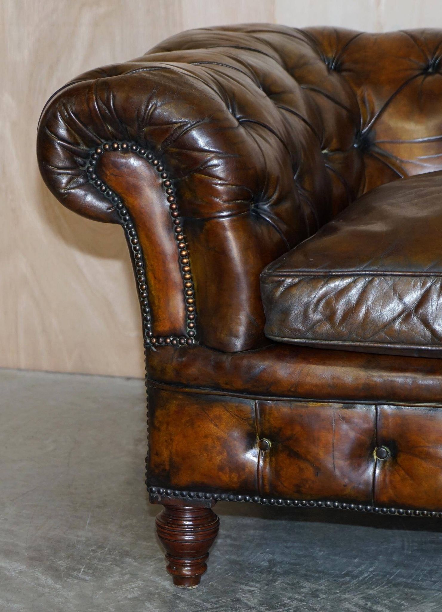 Victorian Chesterfield leather upholstered canapé with feather cushions.
