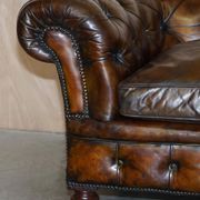 Victorian Chesterfield leather upholstered canapé with feather cushions.