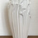 Old white art nouveau vase with flowers and dragonflies