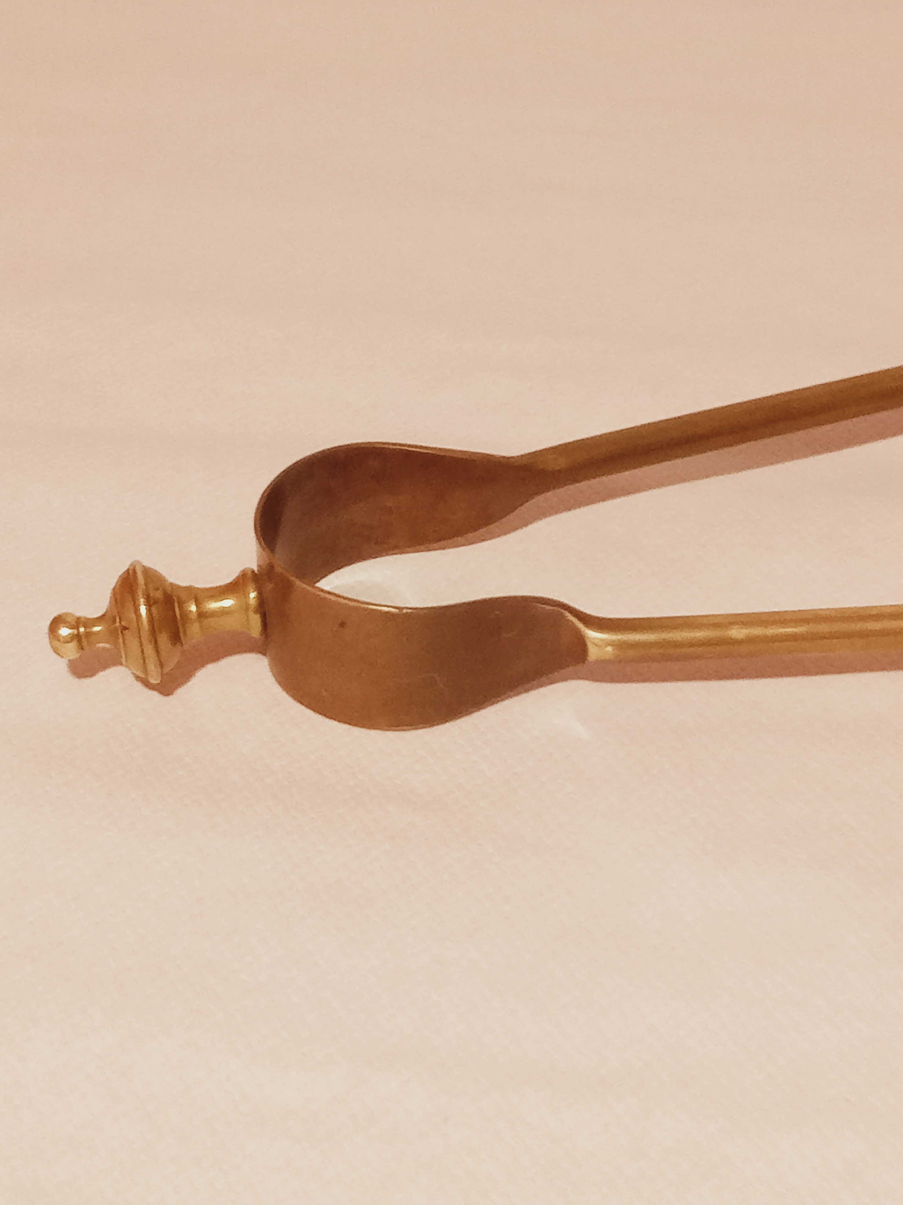 Old bronze or brass fireplace clamp