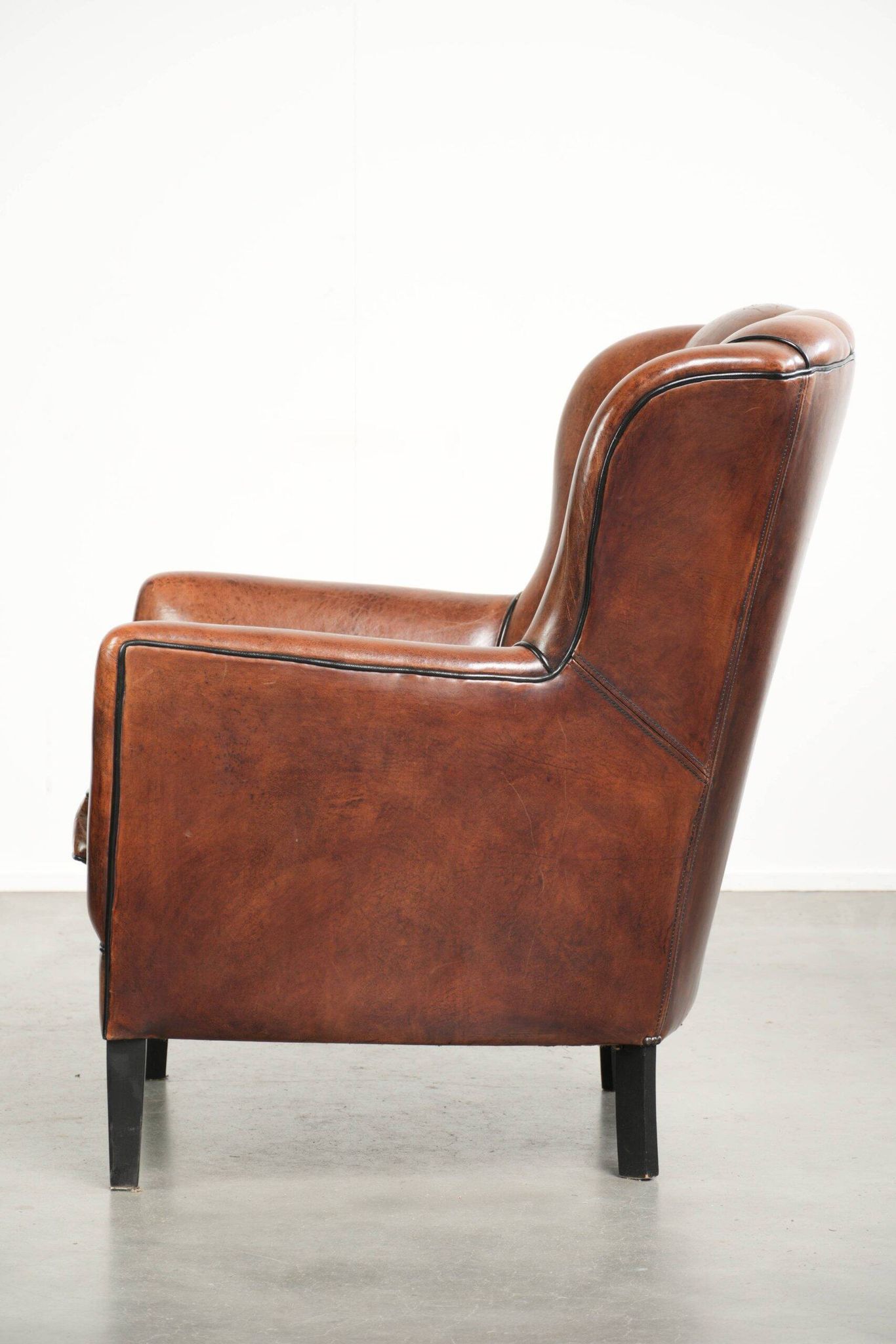 Comfortable sheepskin armchair in unique design finished with black piping