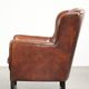Fauteuil en peau de mouton confortable au design unique, fini avec un passepoil noir.