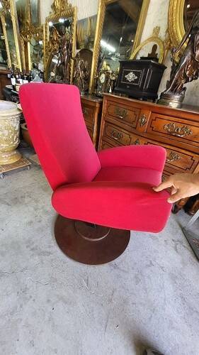 Old cinema chair with a red reclining seat.