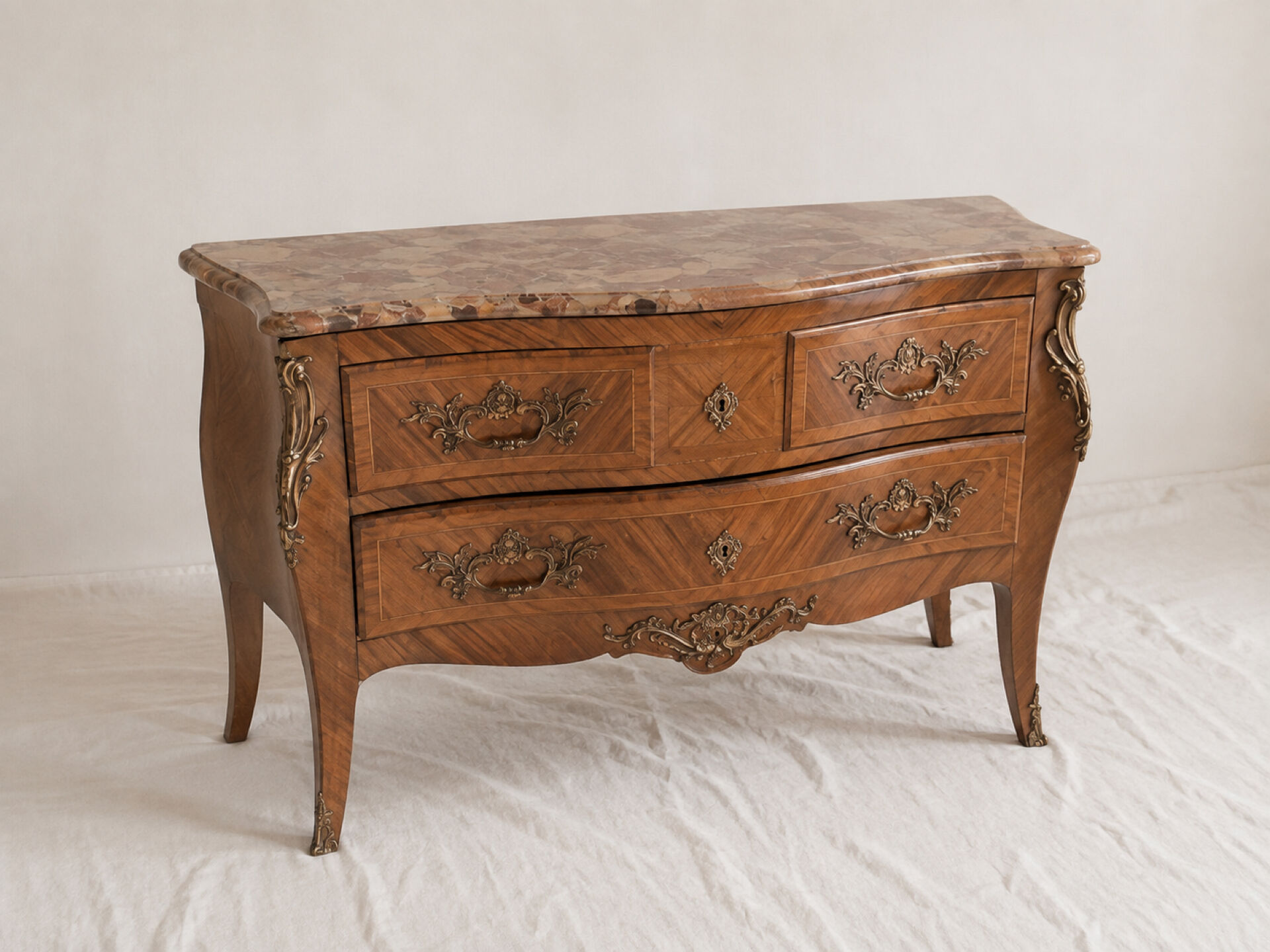 Curved Louis XV style commode in marquetry, veined marble and ornamentation.