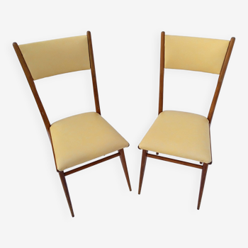 pair of chairs with wooden structure and skai covering