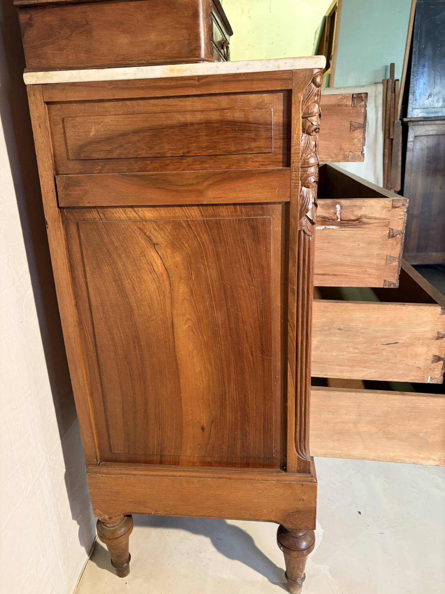 Antique carved wooden dressing table with marble and tilting oval mirror.