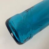 Blue glass bottle with embossed patterns at the bottom. Selters brand.
