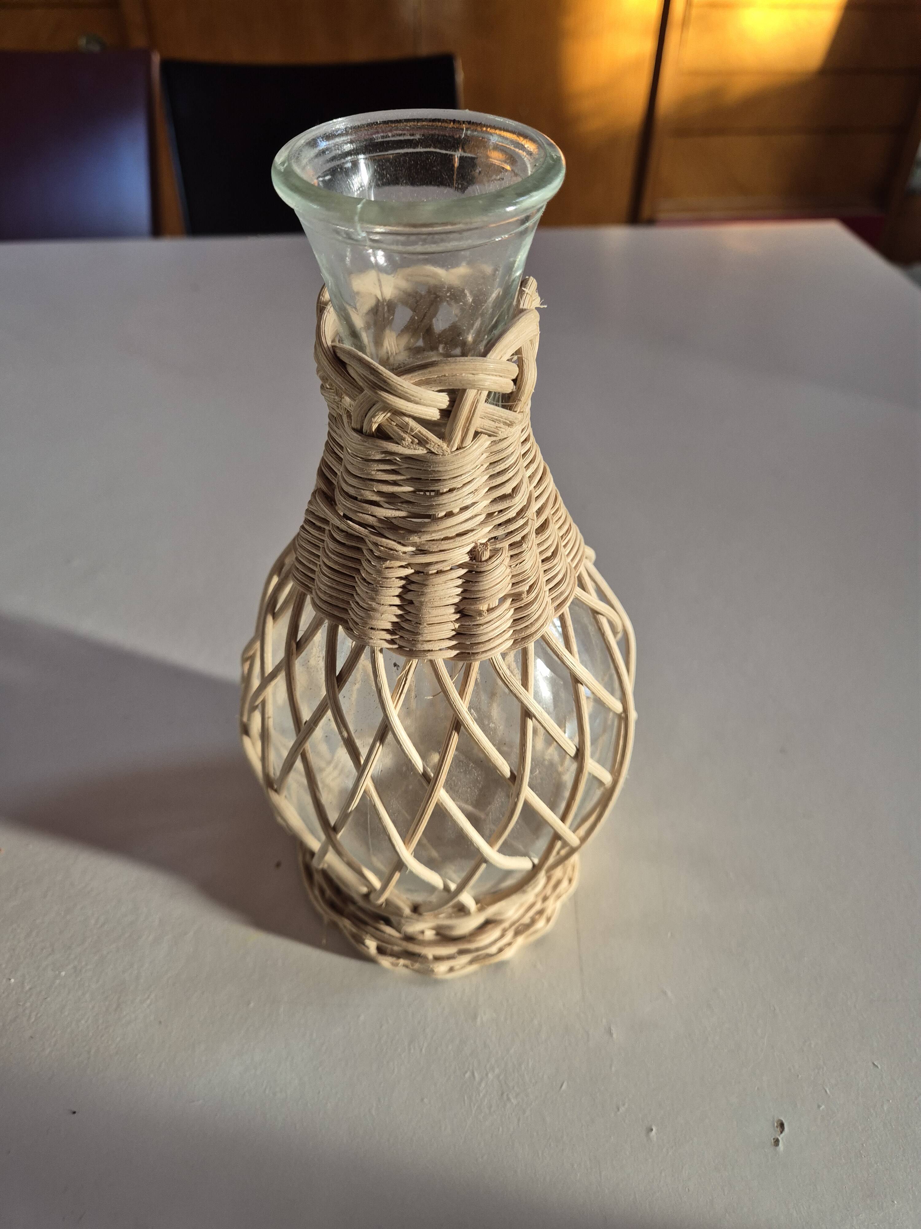 vintage glass vase surrounded by woven rattan