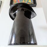 Large black glass vase topped with a 70s hat