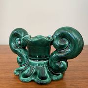 Green ceramic candlestick with curled handles.