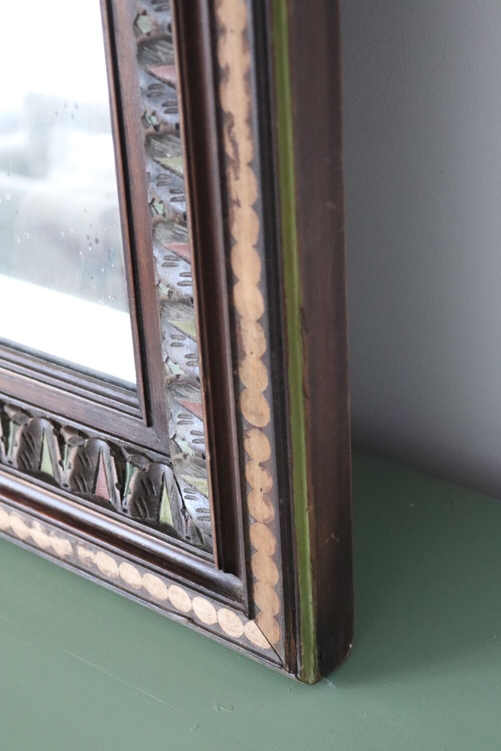 Antique mirror with a carved and painted wooden frame