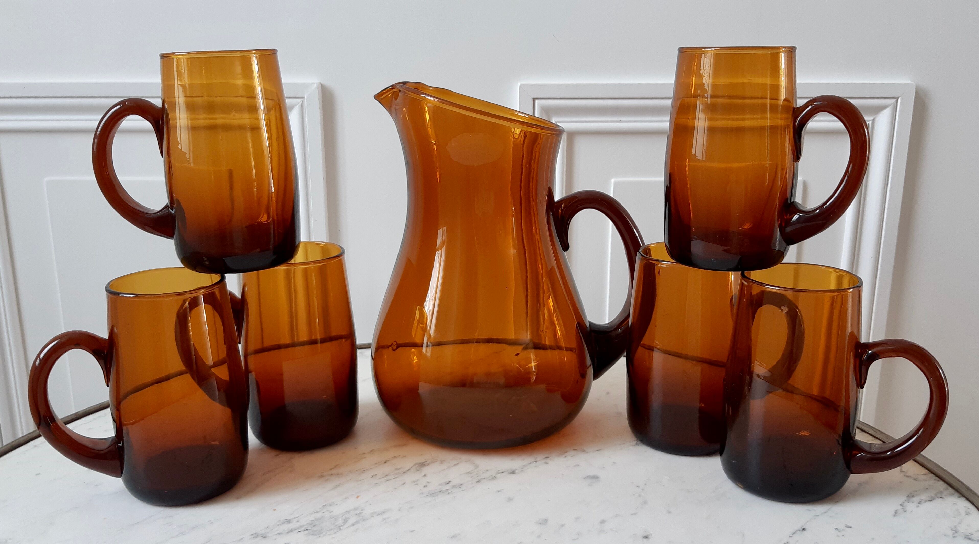 Ensemble composé d’un pichet et de 6 verres ambrés années 70