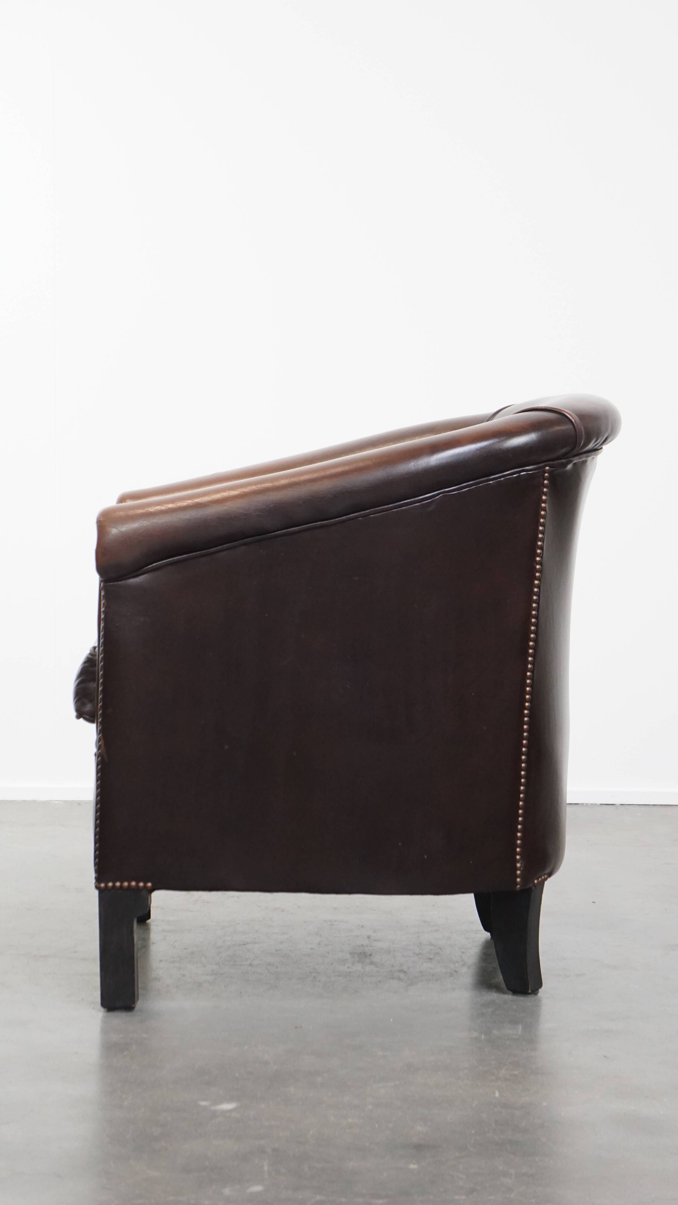 Fauteuil club de couleur foncée en cuir de vachette