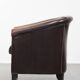 Fauteuil club de couleur foncée en cuir de vachette