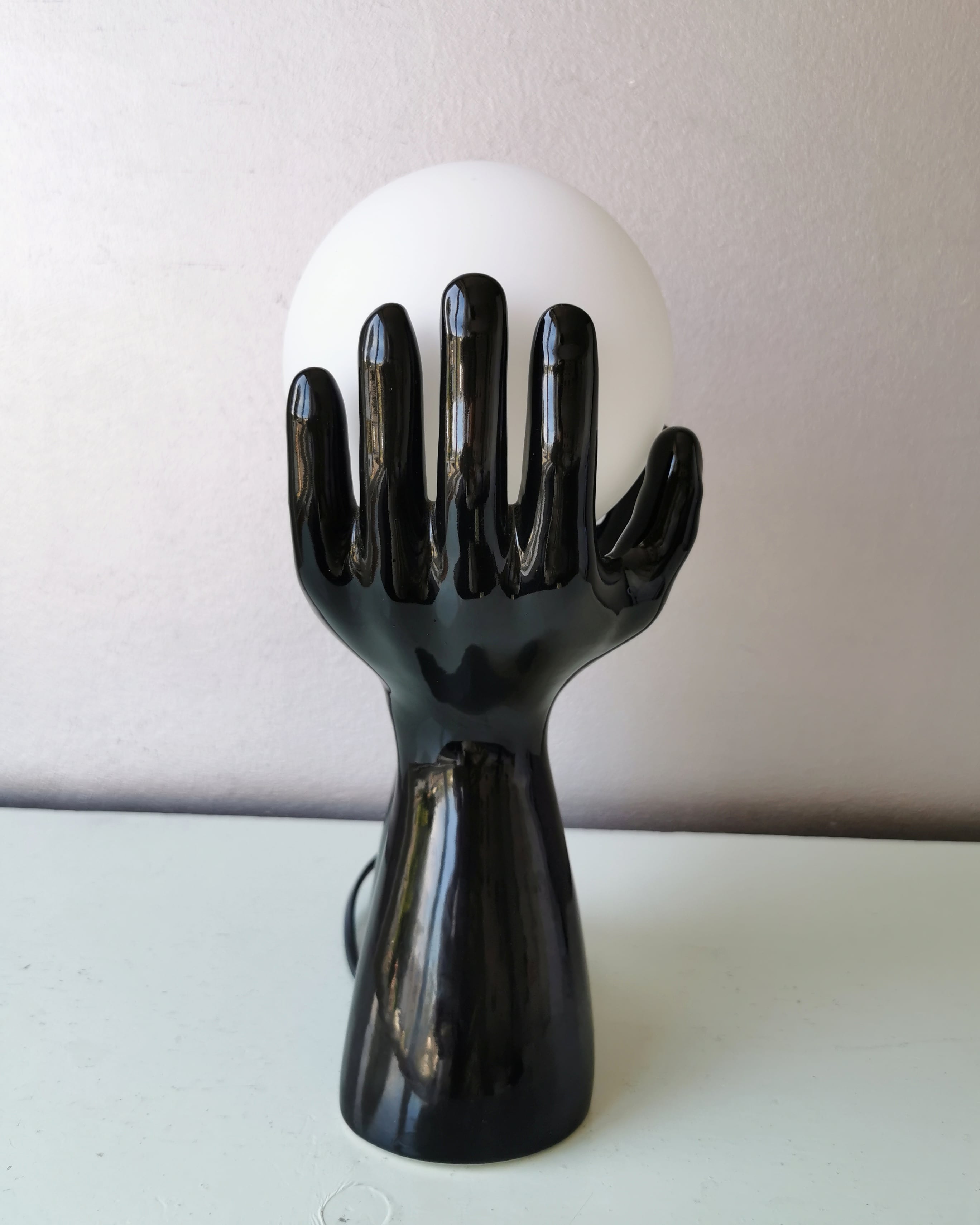 Italian design ceramic table lamp, two hands and glass shade.