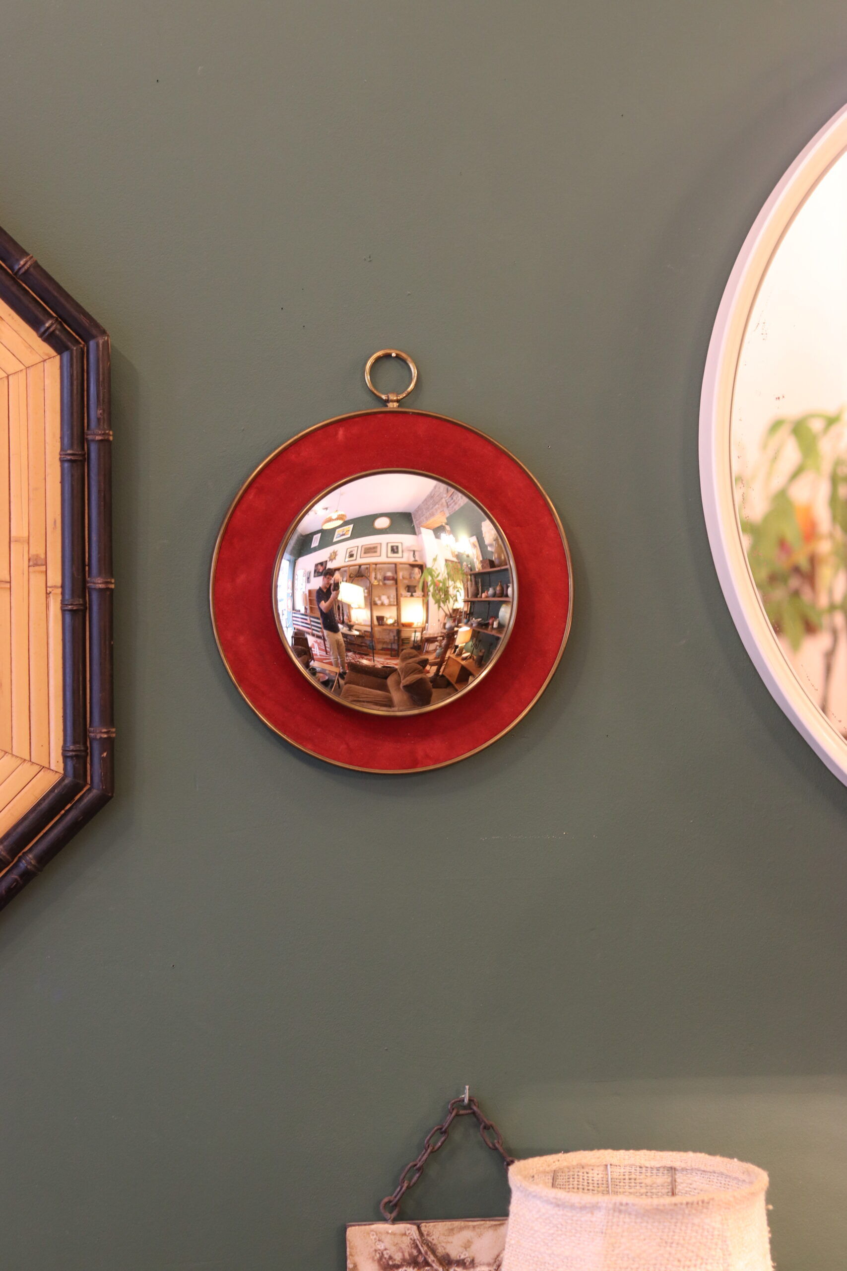 Witch's eye mirror in brass and red velvet