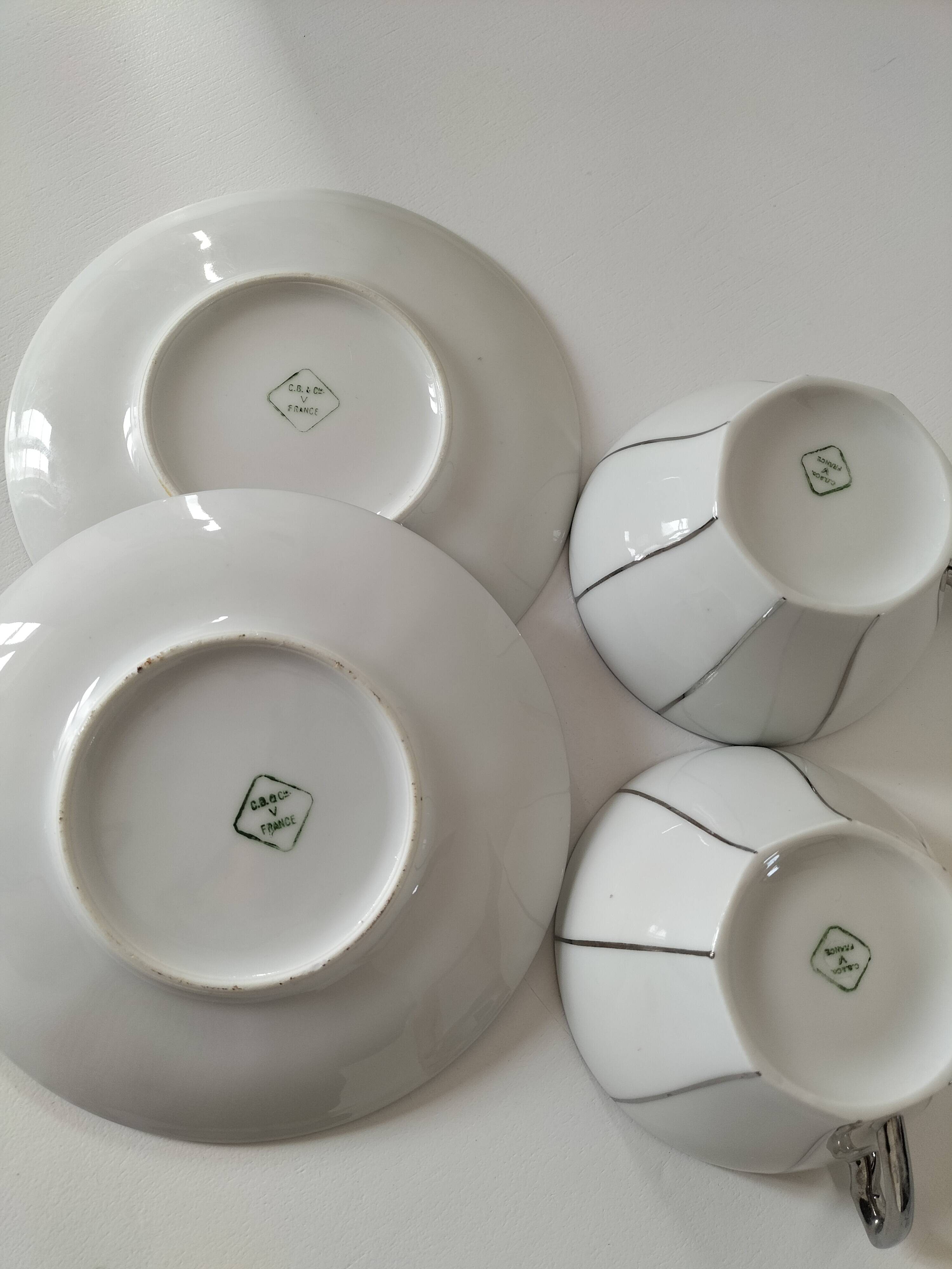 Two Art Deco porcelain cups and saucers with silver trim.