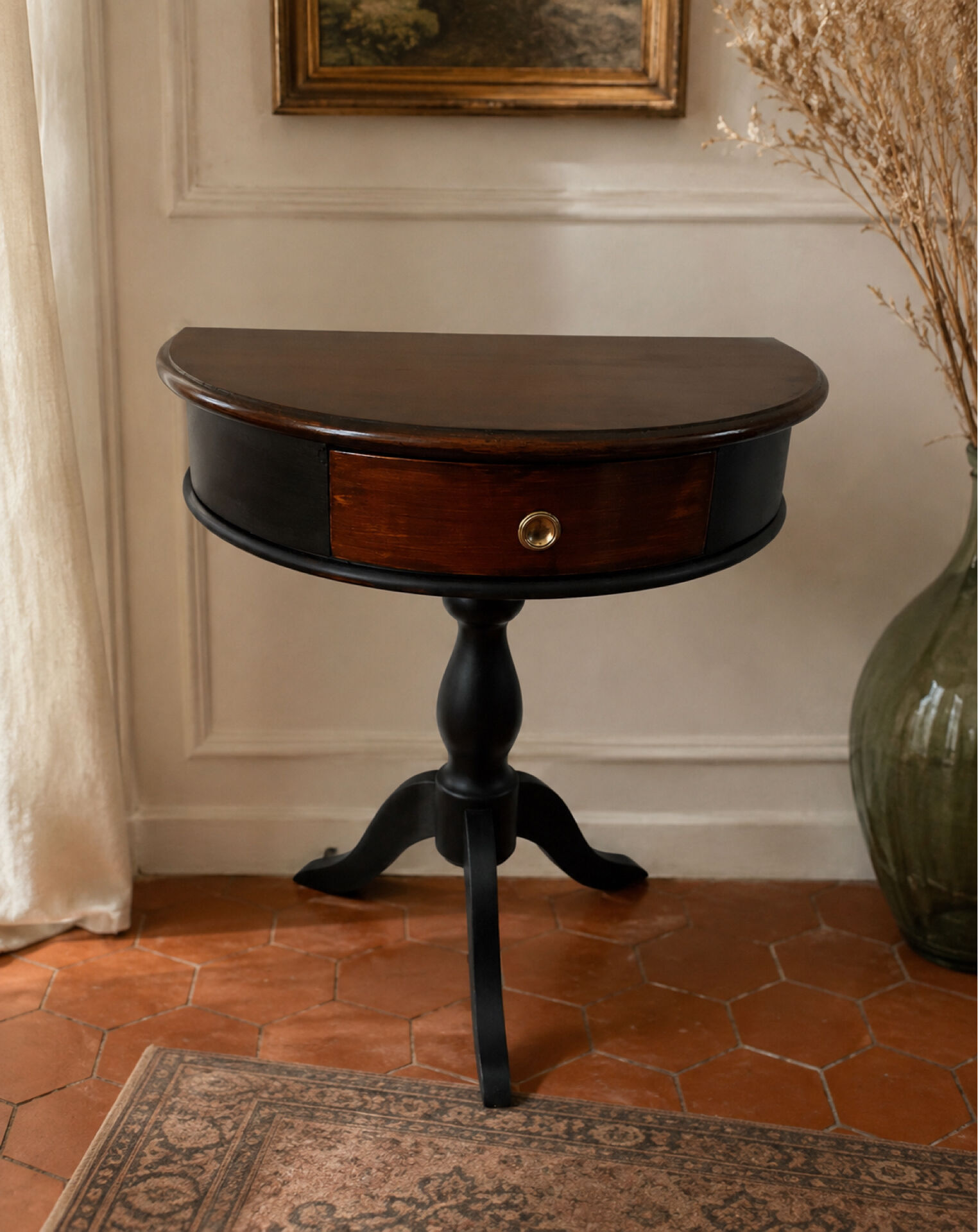 Antique half-moon side table in wood and black.
