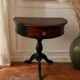 Antique half-moon side table in wood and black.