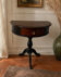 Antique half-moon side table in wood and black.