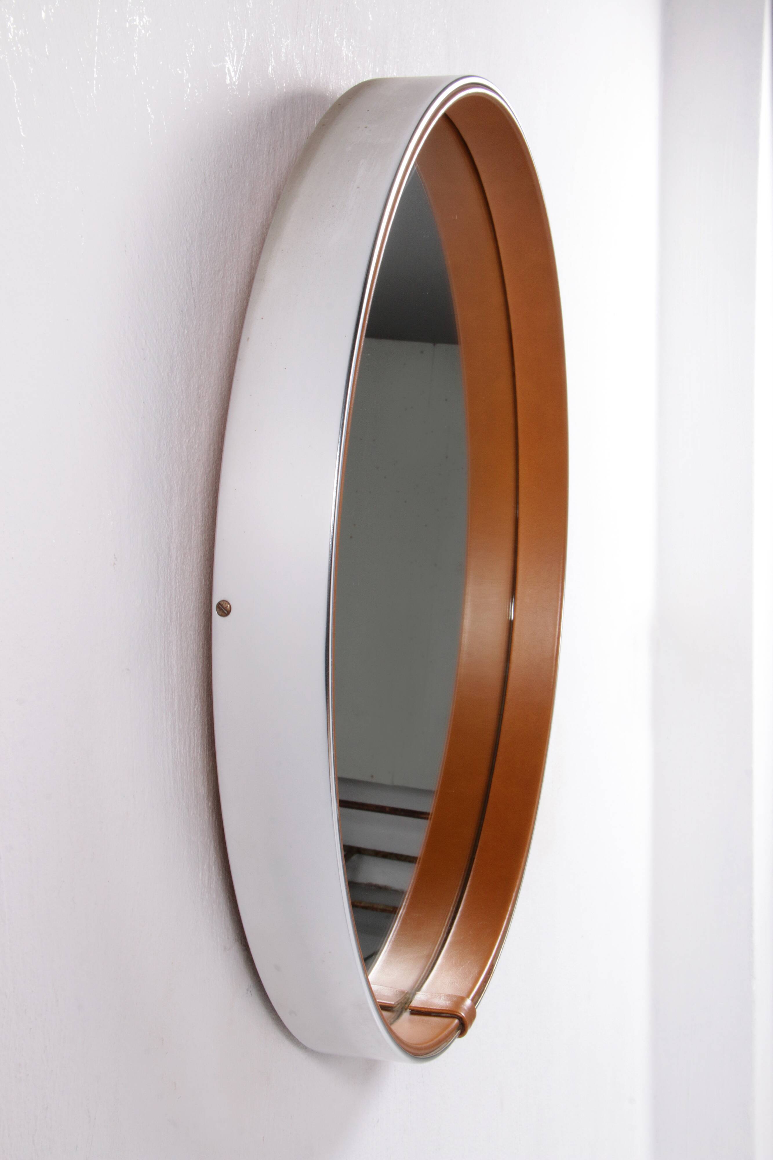 Round mirror covered with leather and chrome, made in France in the 1970s.