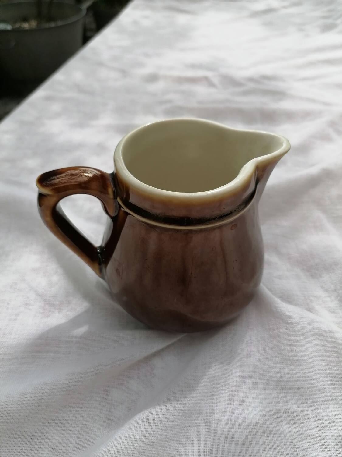 Brown ceramic teapot and milk jugs