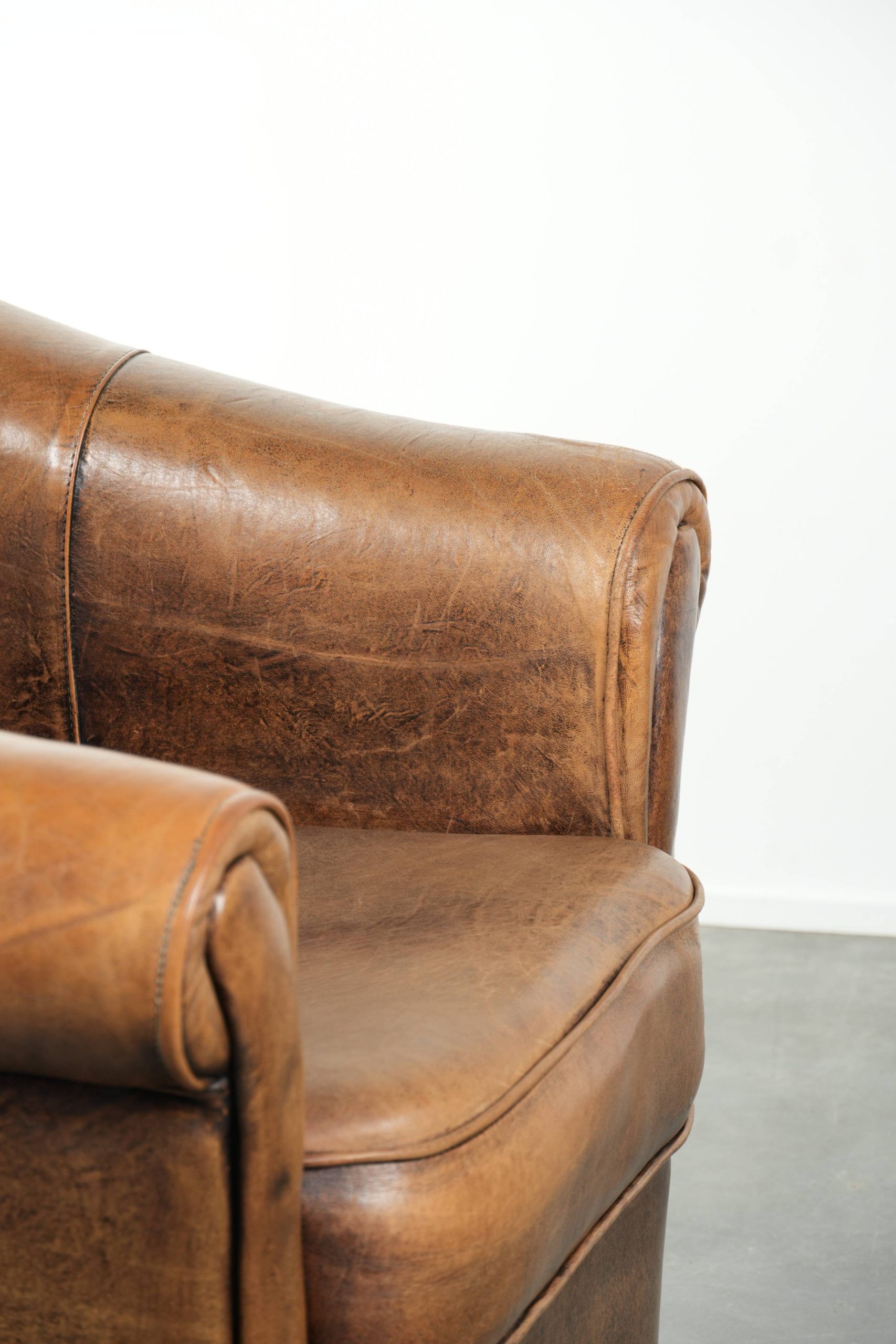 Fauteuil en peau de mouton magnifiquement conçu et confortable, avec un look intemporel et une finition de passepoil assortie.