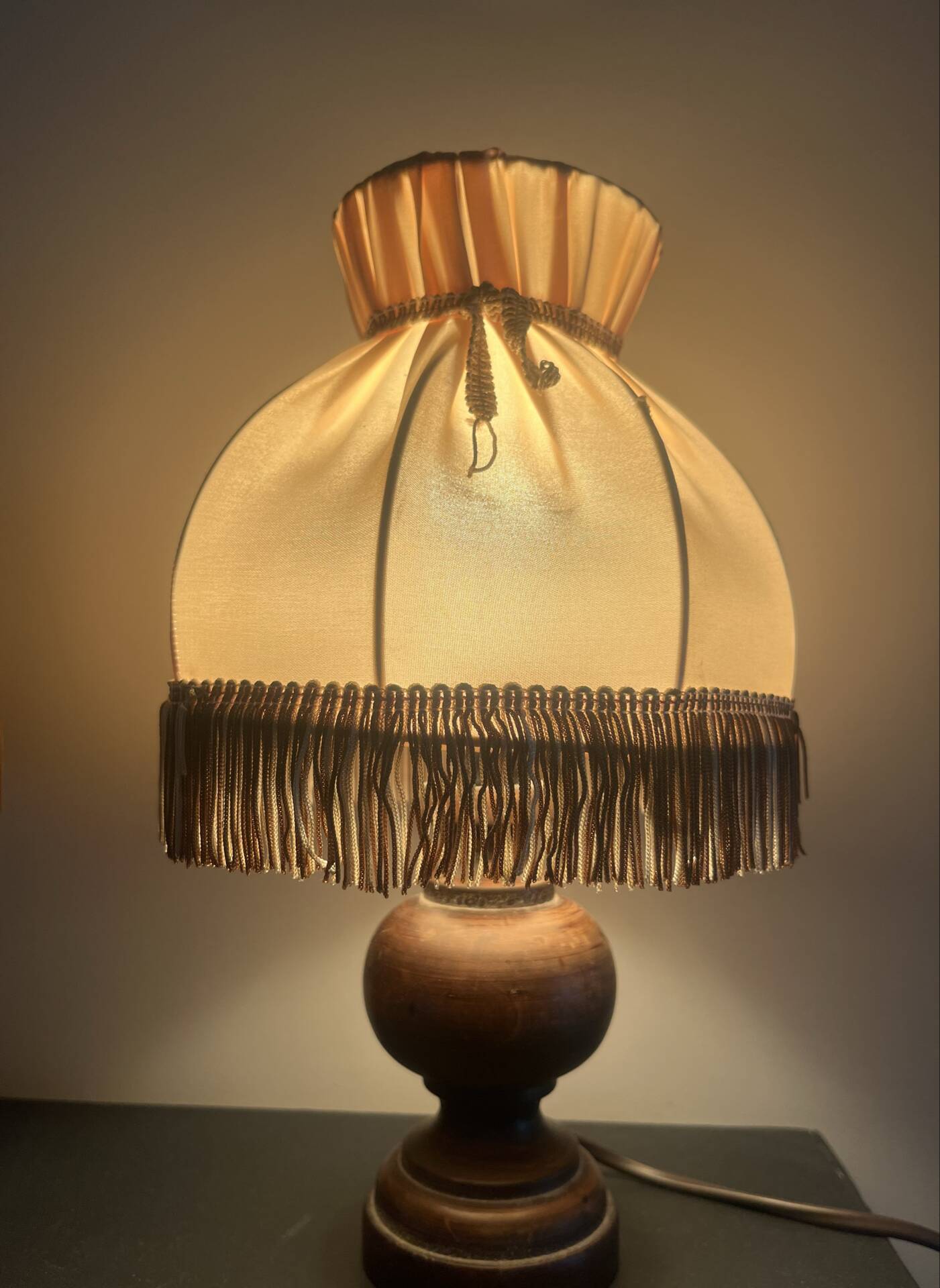 Pair of wooden bedside lamps with vintage fringe lampshades.