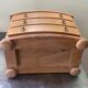 Blonde wooden doll's chest with brass handles.