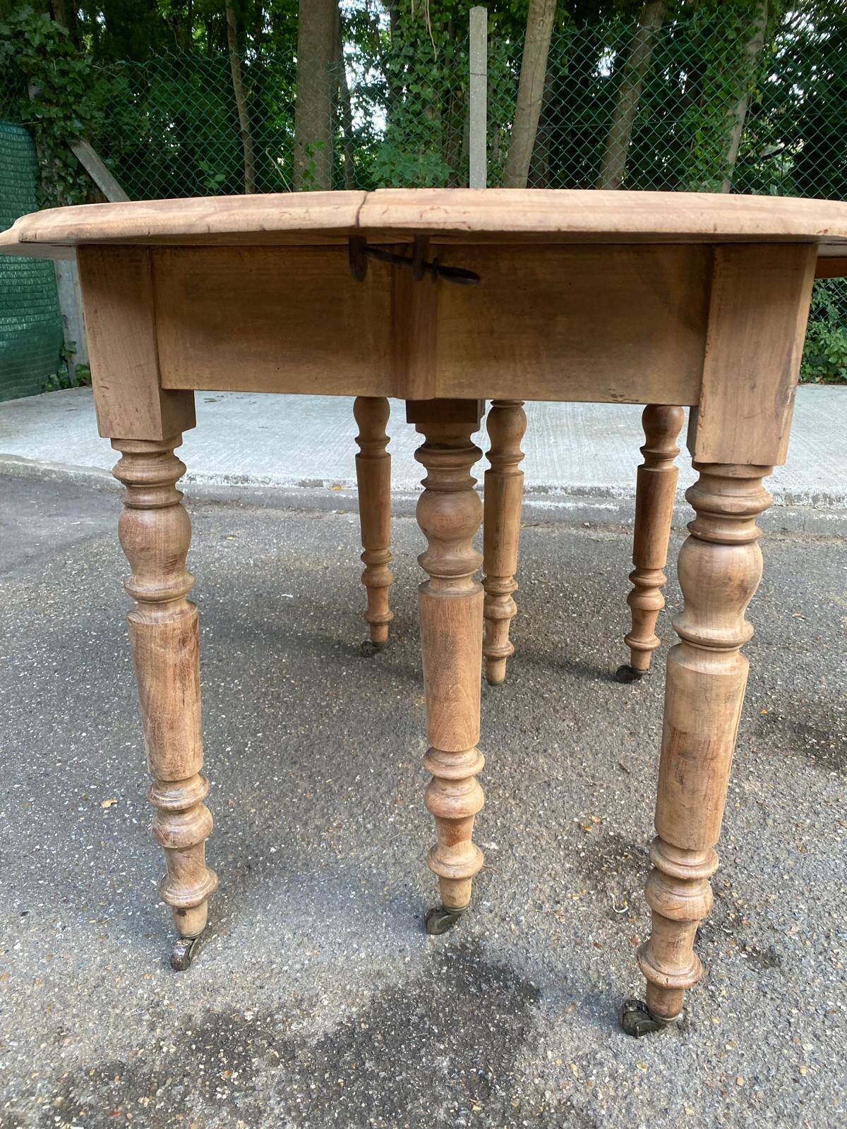 Renovated round extendable dining table with leaves made of solid wood.