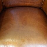 Neat and subtle sheepskin club chair, finished with decorative studs and a fixed seat cushion