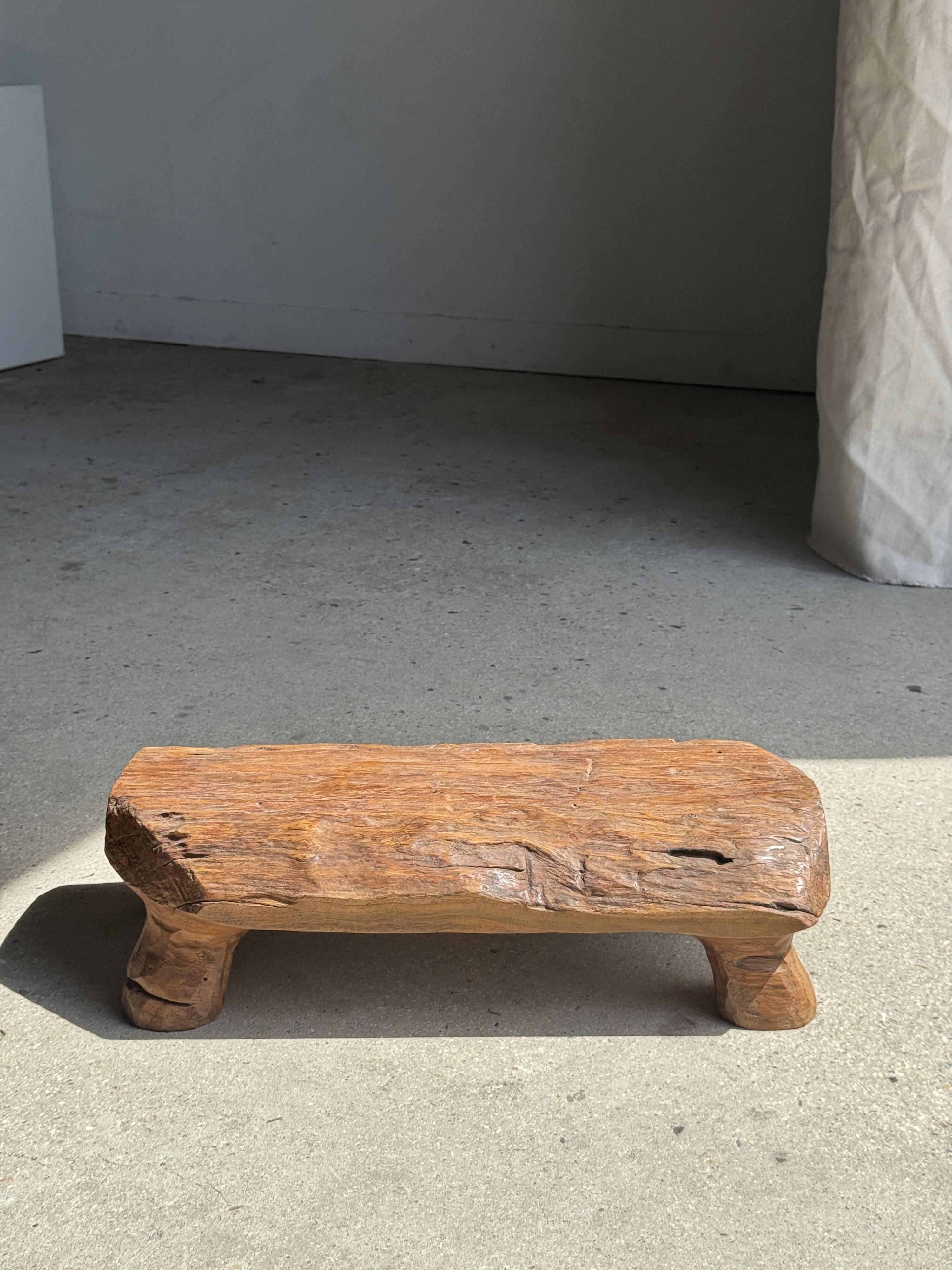 Small stool, footrest in blond teak, organic monoxyle with cut corners.