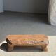Small stool, footrest in blond teak, organic monoxyle with cut corners.