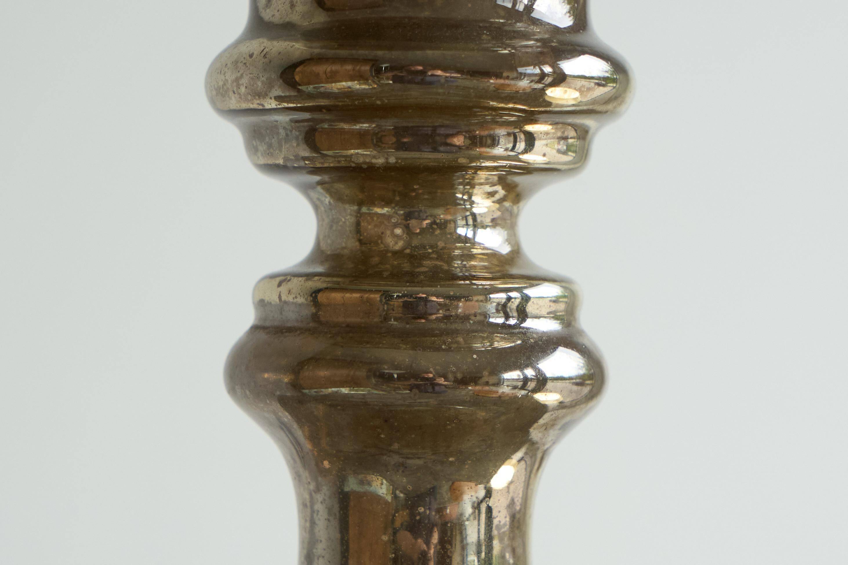 Antique mercury glass candlestick with a patina and silver finish.
