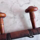 Wall-mounted coat rack with 8 turned wooden hooks in faux bamboo style.