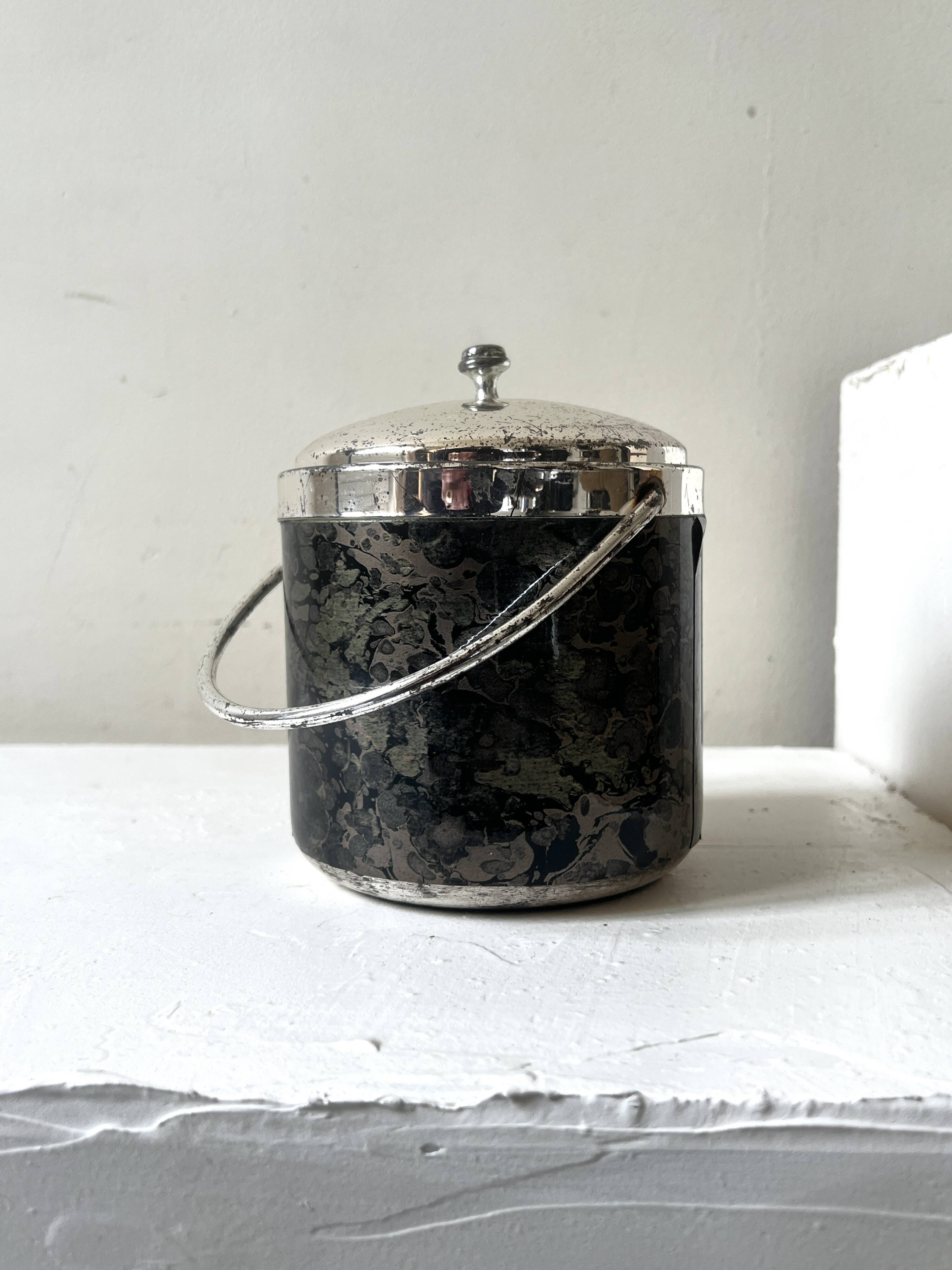 Vintage chrome metal ice bucket with black marbled design, 1970s style.