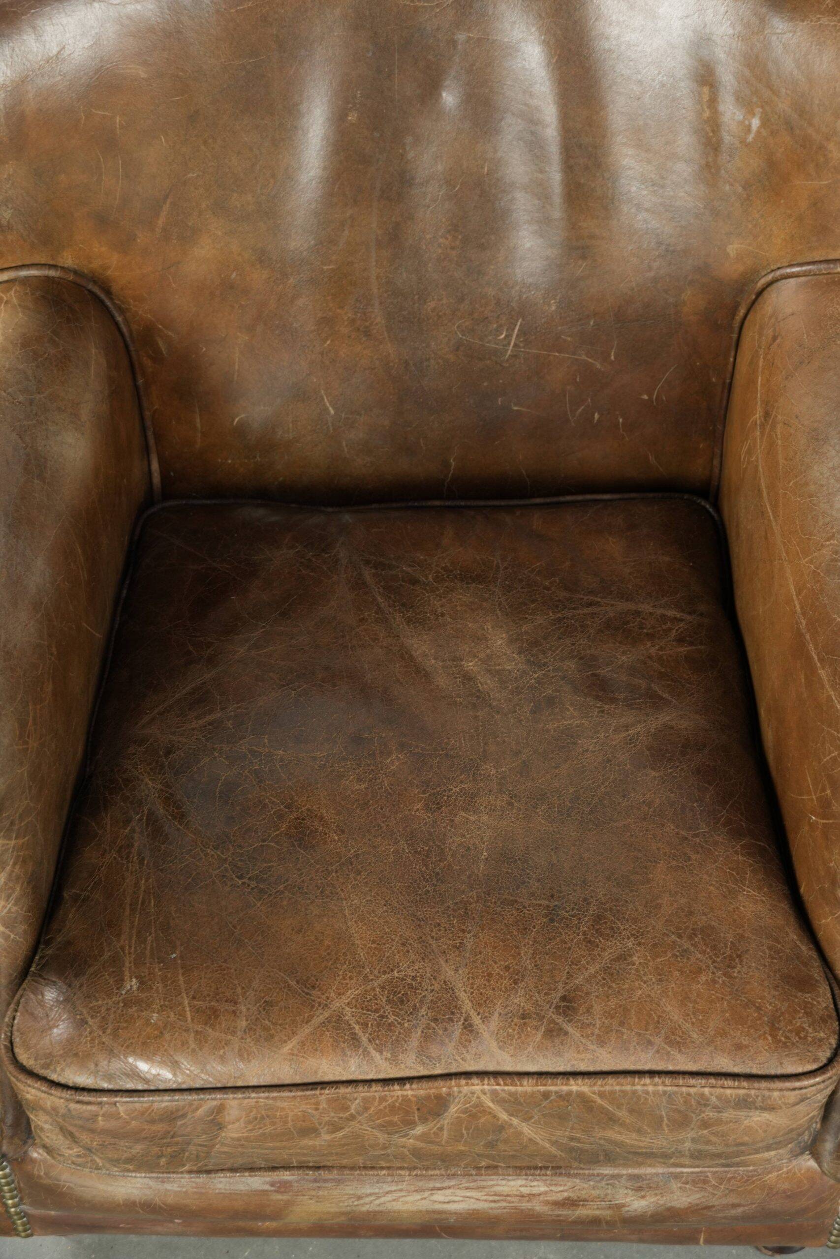 Robust cowhide armchair in a beautifully subtle size with a wonderful patina.