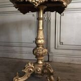 A gilded carved wooden pedestal table with a marble marquetry top
