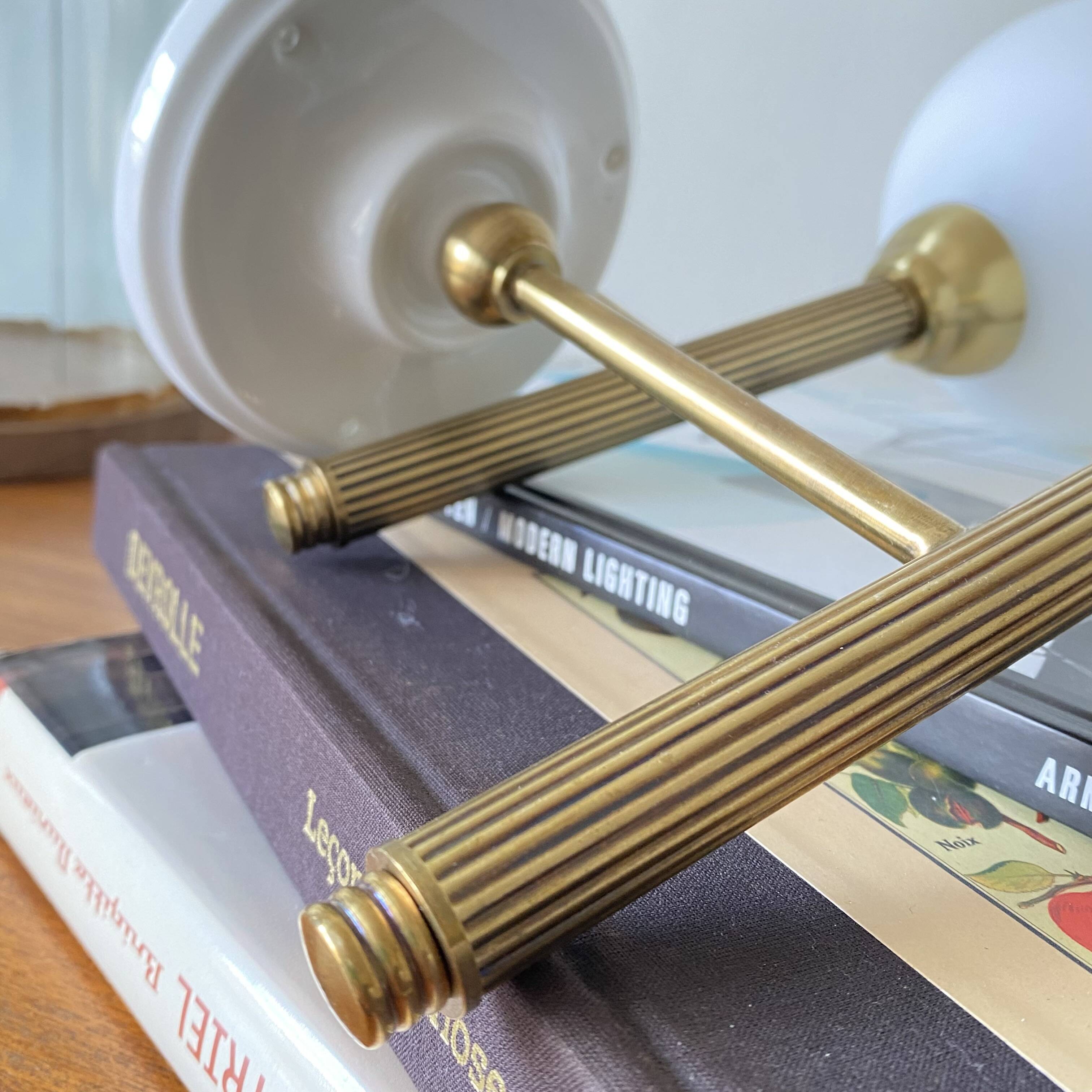 Pair of torch wall lights in brass, white glass and porcelain.