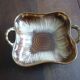 Square dish with brown and gold handles