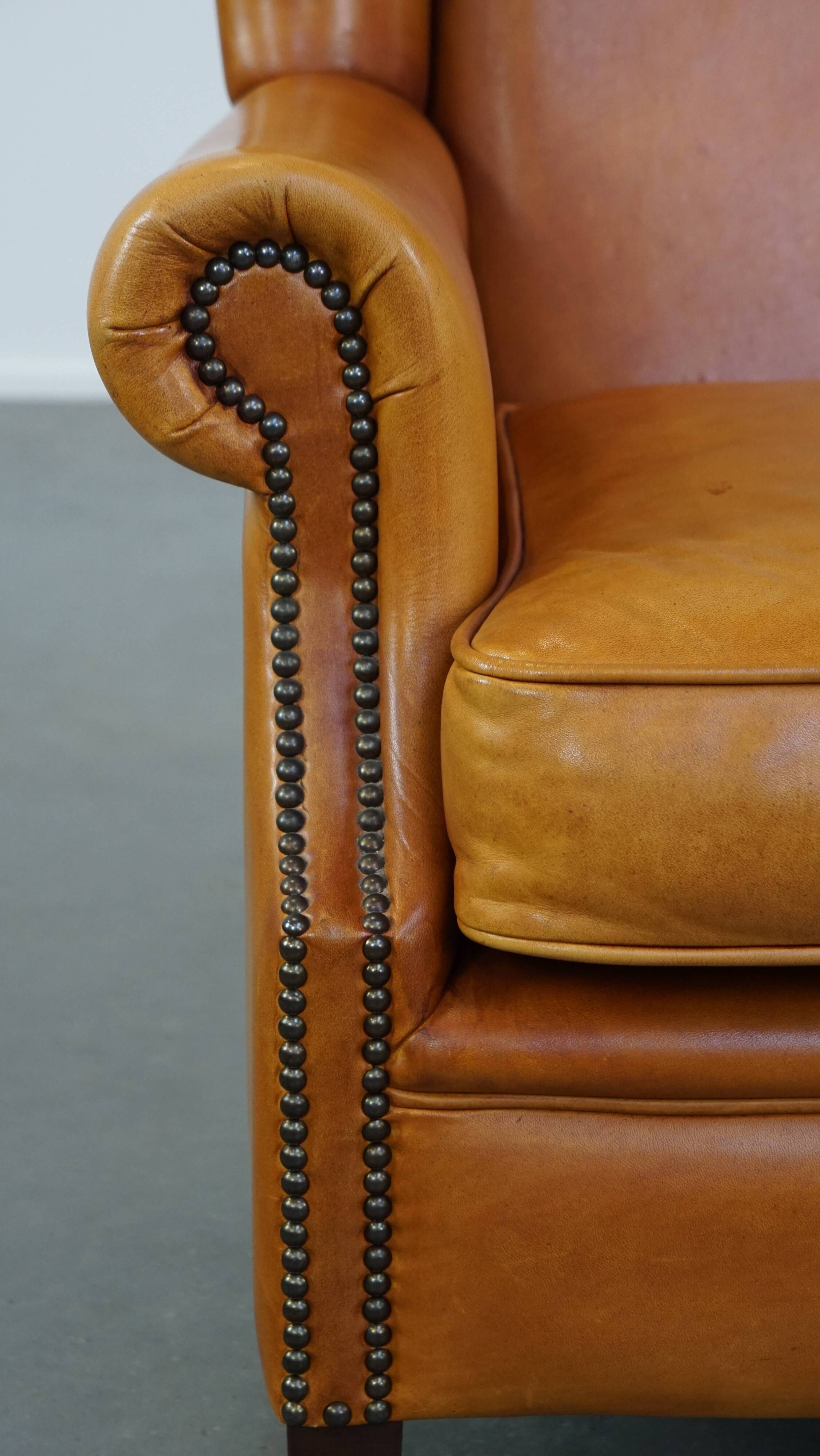 Cow leather wingback chair finished with decorative nails