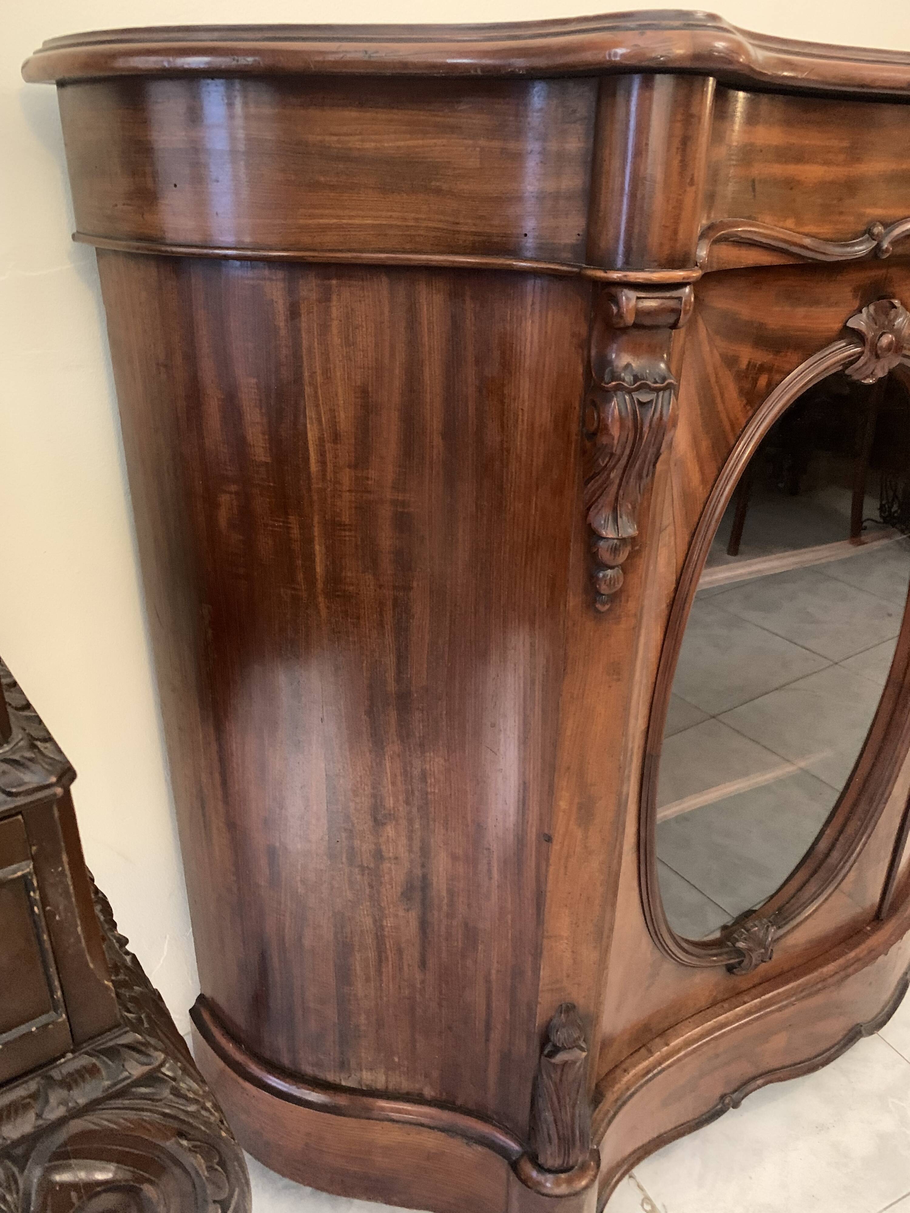 Curved mahogany display cabinet from the Napoleon III period. It has two doors and two shelves.